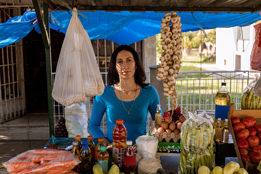 Portrait of a confident small business owner, a mid adult woman standing behind her Farmer market stall