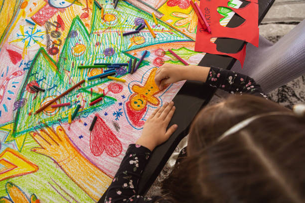 istock Creative and cute girl drawing a gingerbread cookie man on the paper 1348377543
