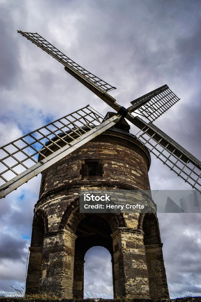 Chesterton windmill stands tall with moody sky on rainy day Agricultural Field Stock Photo