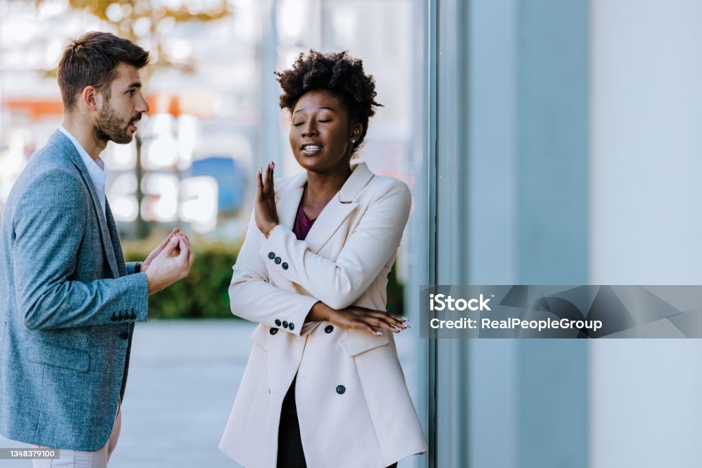 Young mixed-race couple arguing in the city street Sad young black woman and man outdoor on street having relationship problems Rejection Stock Photo