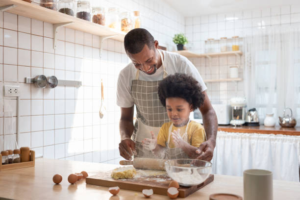 istock African American father and his son playing flour while doing bakery in white kitchen 1348381434