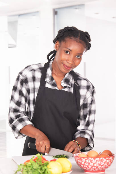 istock Afro american woman chopping parsley while smiling at the camera 1348384698