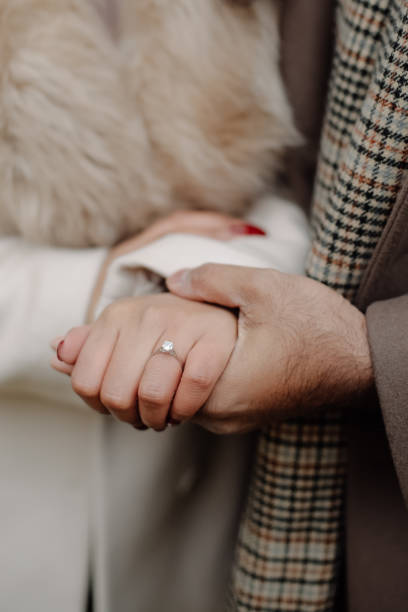 istock Engaged couple holding hands close up, just proposed with diamond ring 1348385783