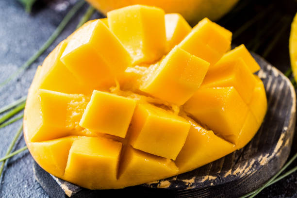 istock Orange mango on a wooden board 1348389124