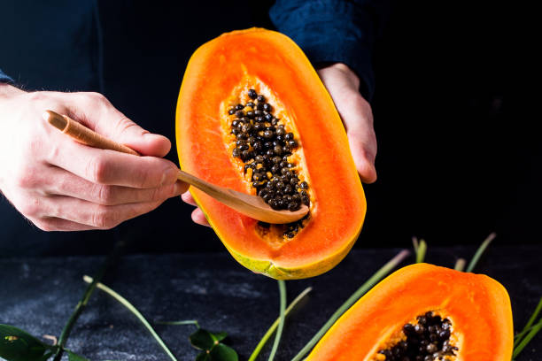 istock Half orange papaya in hands 1348389128