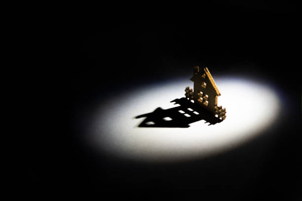 istock symbolic house casts a long shadow in a circle of light 1348389176