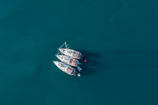 istock Aerial view to three small yachts in a deep blue sea. 1348389380