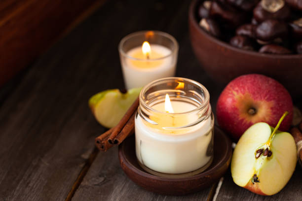 istock Composition with aromatic candles, apple, cinnamon, chestnut. Cozy home atmosphere, aromatherapy. Dark wooden background 1348392583