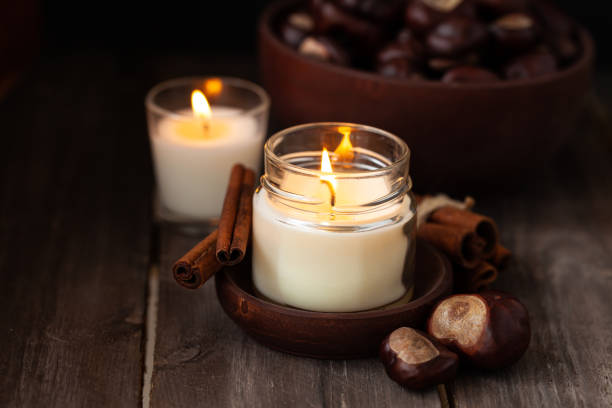 istock Composition with aromatic candles, cinnamon, chestnut. Cozy home atmosphere, aromatherapy. Dark wooden background 1348393107