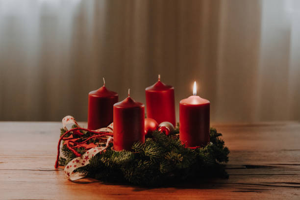 The first candle on the Advent Wreath is burning. Swiss tradition to celebrate four weeks till Christmas Eve. The first candle on the Advent Wreath is burning. Swiss tradition to celebrate four weeks till Christmas Eve. Cozy winter evening mood. advent candle wreath adventskranz stock pictures, royalty-free photos & images