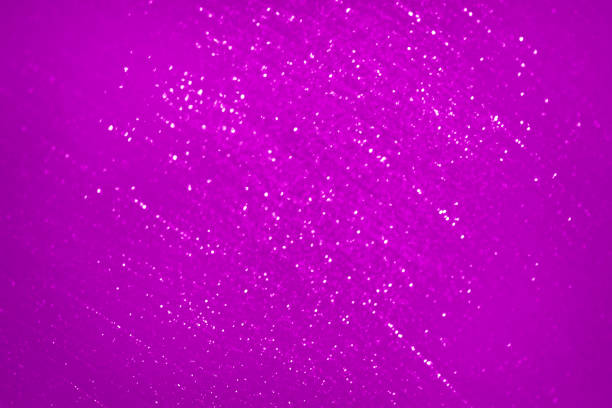 Abstract purple glitter blurred background with a gradient light rays and shadows.
