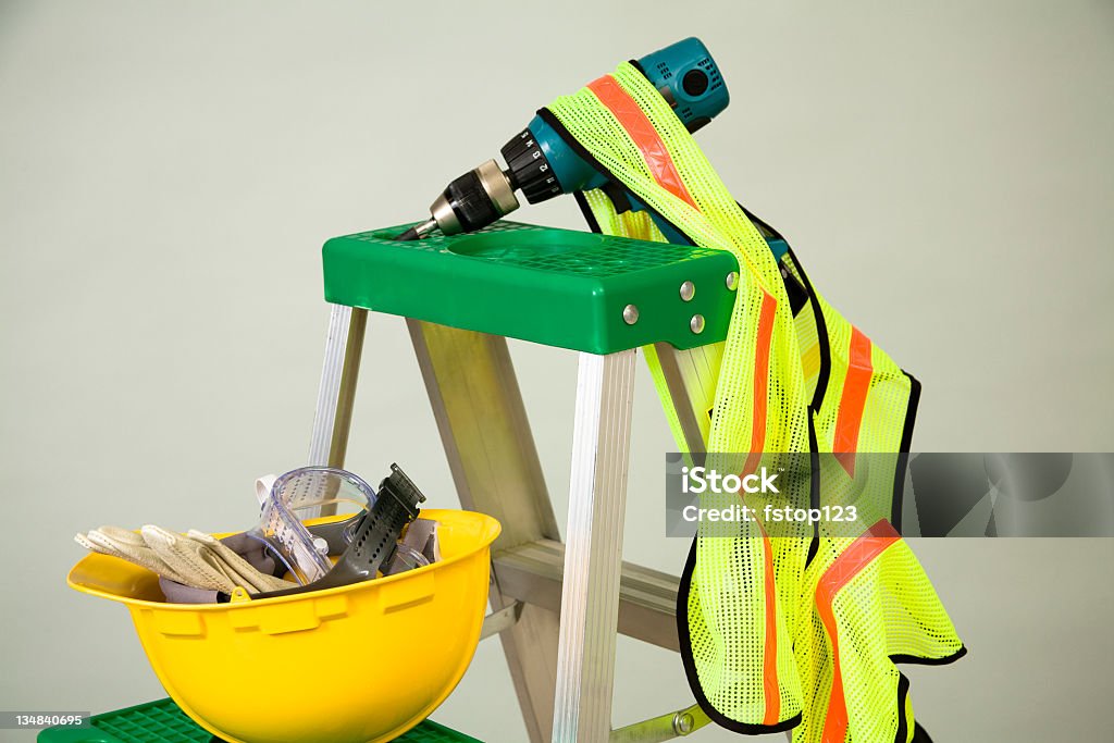Bauarbeiterhelm, Handschuhe, Brille, Bohrer und Sicherheit Weste auf Leiter. Konstruktion. - Lizenzfrei Bauarbeiterhelm Stock-Foto
