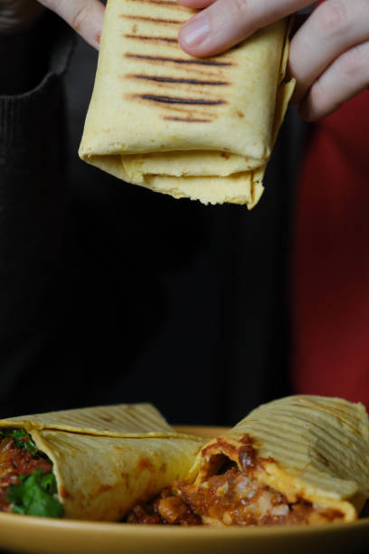 istock Unrecognizable person is tasting homemade burrito 1348409029
