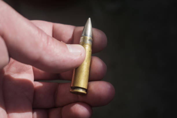 Crime evidence - concept. Cartridge, gun bullet held in the palm. scuff marks photos stock pictures, royalty-free photos & images