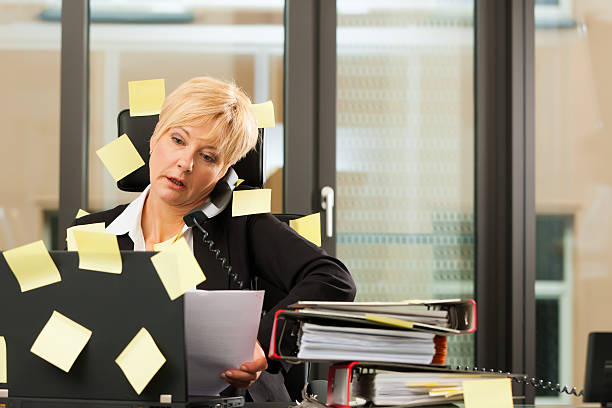 A stressed businesswoman multitasking in an office