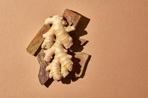 istock Textured ginger lies on stones against a brown background. 1348418877