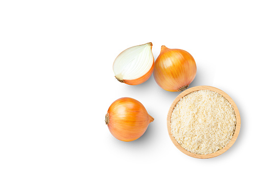 Ground onion or onion powder in wooden bowl and fresh onion with half sliced isolated on white background. Top view. Flat lay.