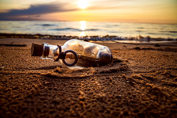istock Message in the bottle against the Sun setting down 1348424944