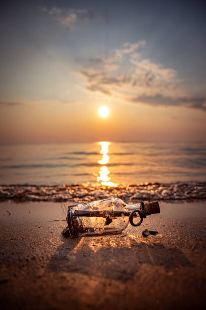 istock Message in the bottle against the Sun setting down 1348425462