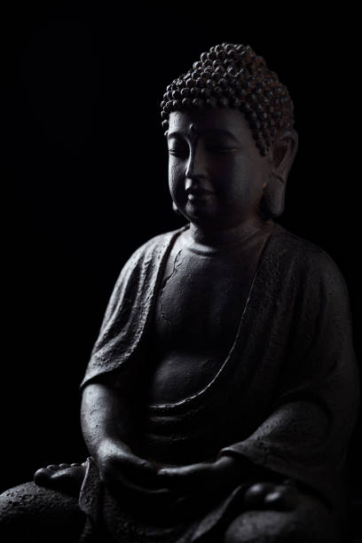 istock Meditating Buddha Statue isolated on black background. Copy space. 1348429783