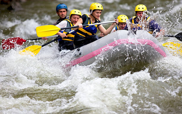 gruppe wildwasser-rafting auf unebenem river - sports team sport rowing teamwork rafting stock-fotos und bilder