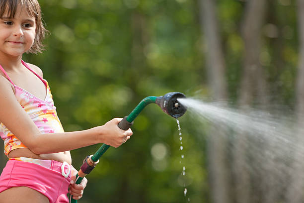 istock Girl waters the lawn from a hose 134845367