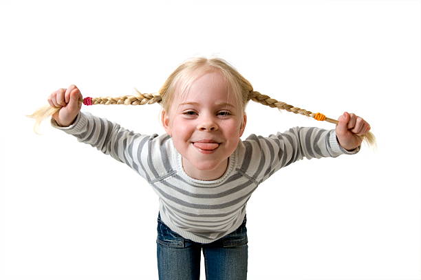 girl with plaits puts out tongue