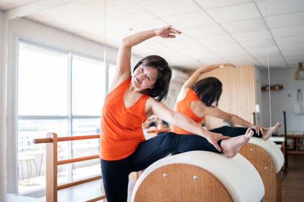 istock Mature woman stretching on the barrel at a pilates studio 1348460157