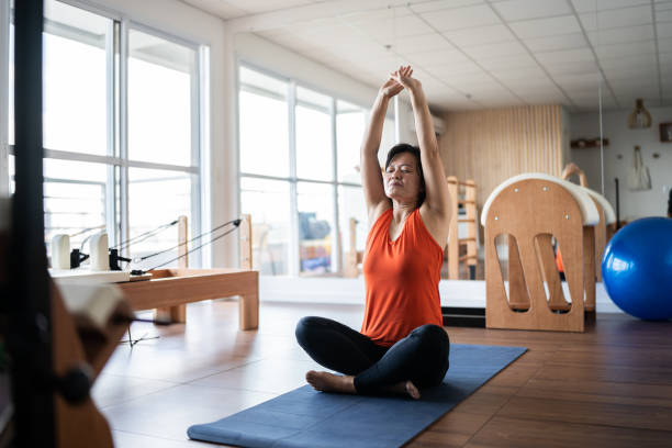 istock Mature woman stretching at pilates studio 1348460635