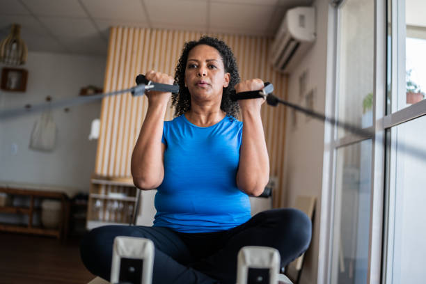 mature woman exercising at a pilates studio - women common 40s candid imagens e fotografias de stock