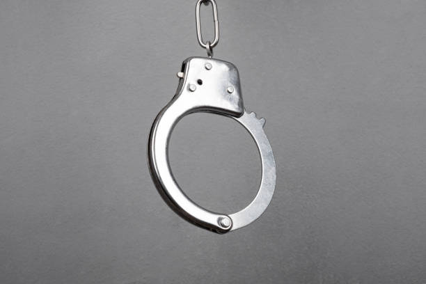 istock metal handcuffs on a gray wall background close-up 1348468353
