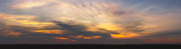 istock Sunset in orange tones with fluffy clouds and trees. 1348470140