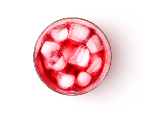 Glass of red juice Red juice with ice cubes in glass isolated on white background. Top view. Flat lay. red drink stock pictures, royalty-free photos & images
