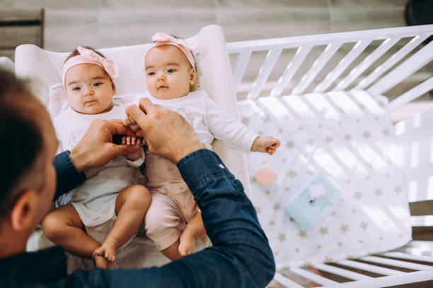 отец и его маленькие девочки - twin newborn baby baby girls стоковые фото и изображения
