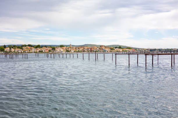 View in cloudy weather over the village of Bouzigues, on the edge of the Thau lagoon, from the oyster beds (Occitanie, France) stock photo