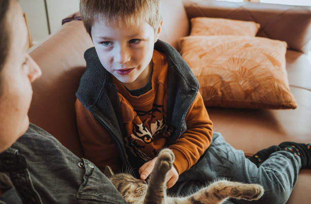 istock Mother and son playing with a cat at home 1348512872