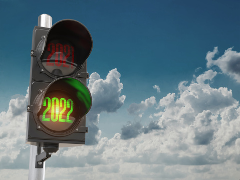Traffic light with green light 2022 and red 2021 on sky background. Start New 2022 Year concept.