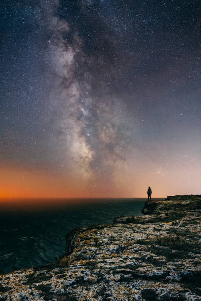 istock Man standing under the Milky Way by the sea 1348528250