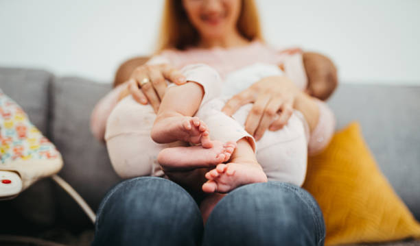 Mom is breastfeeding twins stock photo