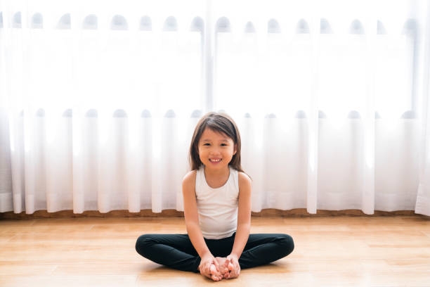 Asian happy girl doing Yoga in bedroom stock photo