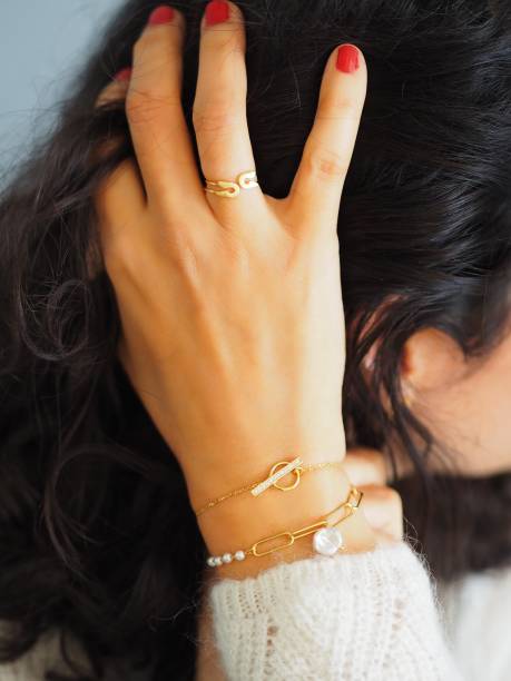 istock Gold bracelets accumulation on a woman wrist wearing a white wool winter pullover 1348543266