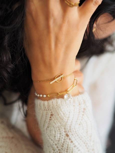 istock Gold bracelets accumulation on a woman wrist wearing a white wool winter pullover 1348543270