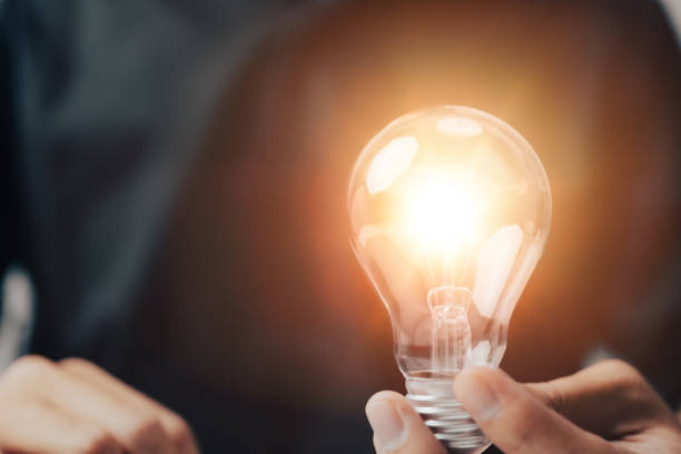 istock New innovative concept. Concepts for solutions, brainstorming, and inspiration The guy is holding a light bulb in his hand. Copy space background. 1348544669