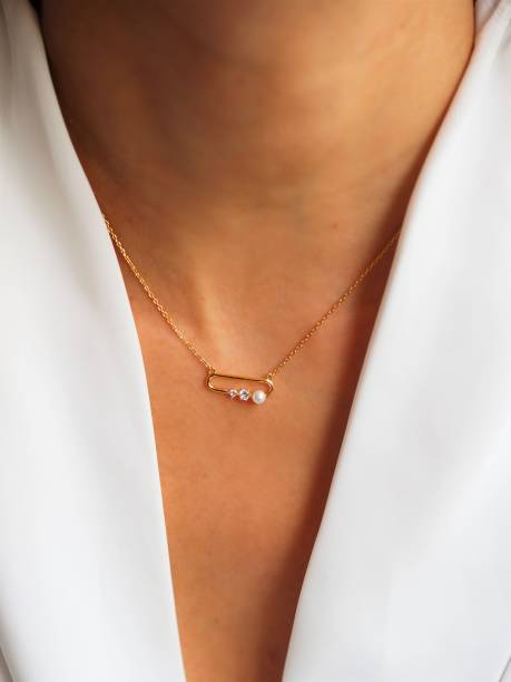 Safety Pin necklace on a white jacket stock photo