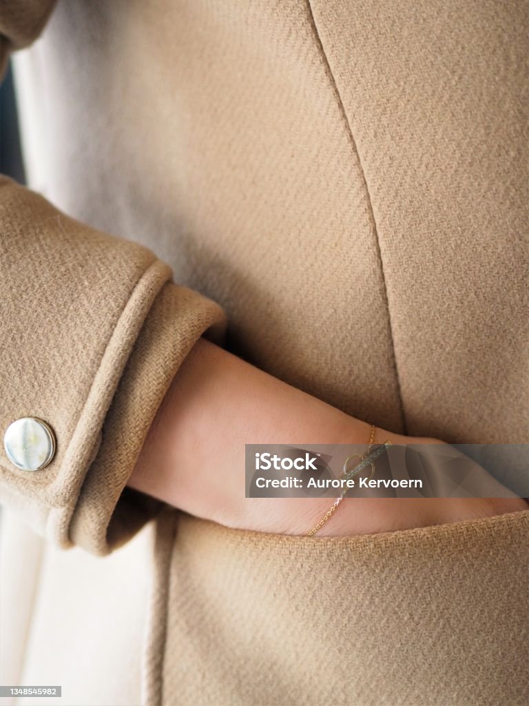 Diamond and Gold bracelet on a woman wrist on a camel coat Coat - Garment Stock Photo