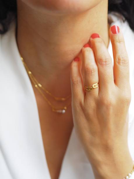 istock Gold ring and necklaces accumulation on a white jacket 1348545985