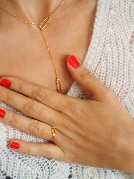 istock Safety Pin Necklace and ring on a white wool pullover 1348549311