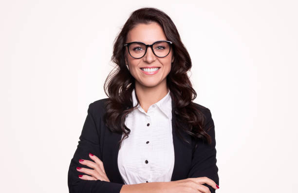 Confident business lady in eyeglasses smiling at camera Happy successful adult businesswoman in formal outfit and stylish glasses smiling and looking at camera while standing with arms crossed against white background businesswoman stock pictures, royalty-free photos & images