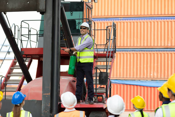 istock male engineer standing on crane car using fire extinguisher with factory workers in containers warehouse storage 1348561533