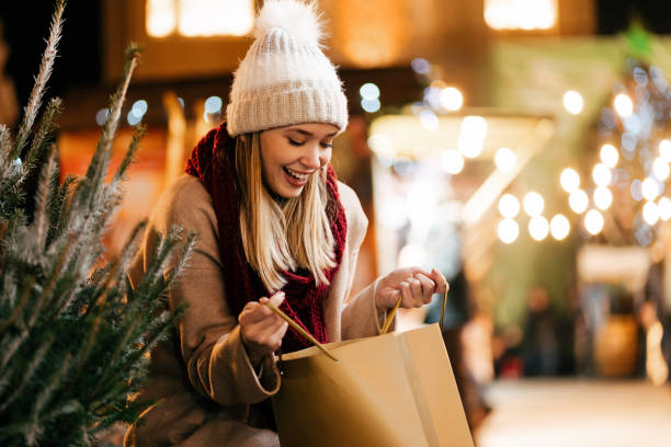 クリスマスプレゼントと市場で木を選ぶ幸せな若い美しい女性 - christmas bag shopping bag gift ストックフォトと画像